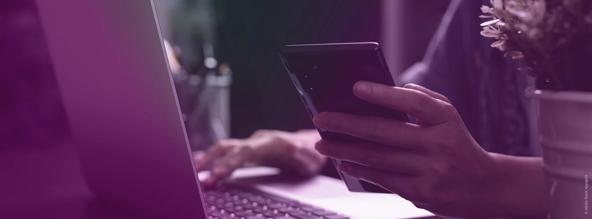 Hombre trabajando en un escritorio con un smartphone en la mano