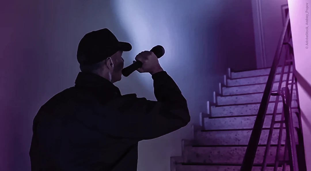 Security guard shining a flashlight up the stairs in a staircase