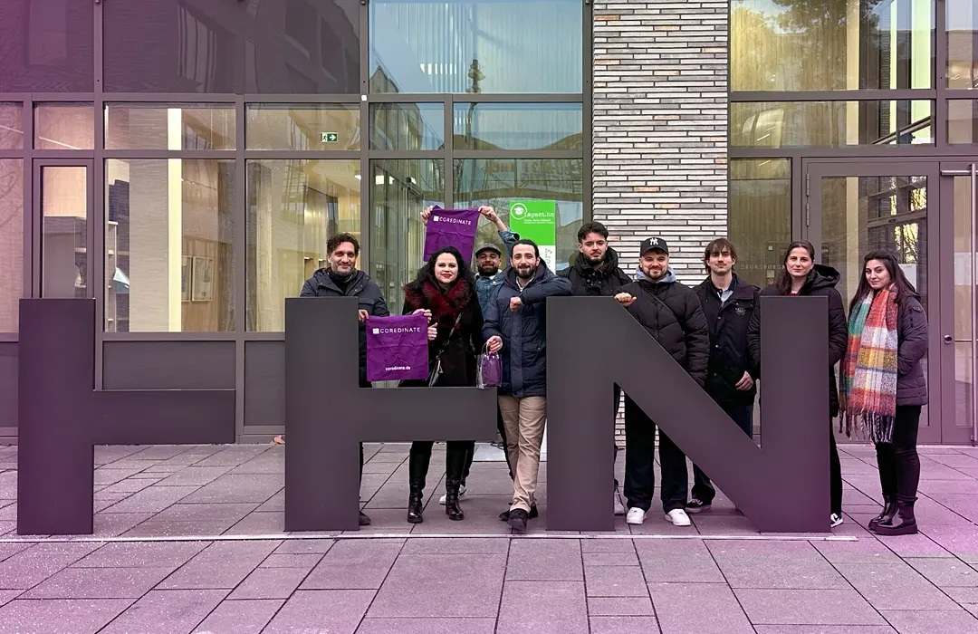 Wirtschaftsinformatik-Studenten und Daniela Gröbel-Becker, CMO von COREDINATE, auf dem Campus der Hochschule Heilbronn zur Besprechung einer Projektarbeit.