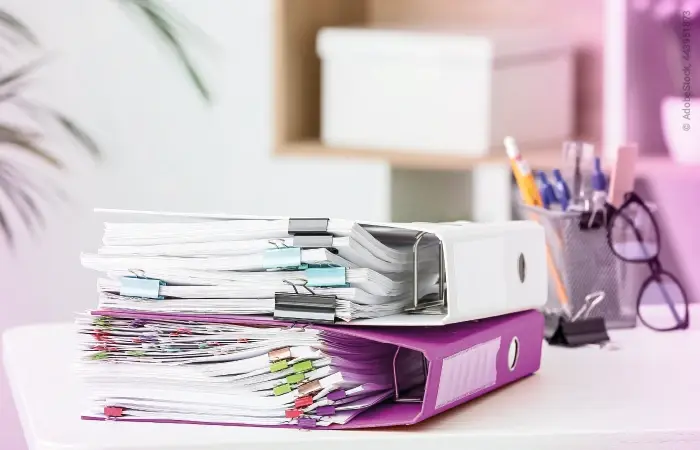 Ein Stapel Dokumente in zwei Ordnern auf einem Schreibtisch